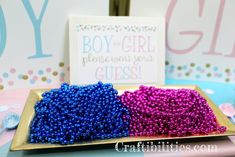 two trays filled with purple and blue beads next to a sign that says boy or girl