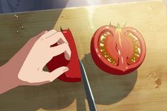 a person cutting up a tomato on top of a wooden cutting board with a knife