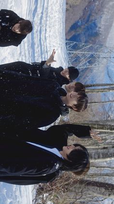 three people standing in the snow with their hands up