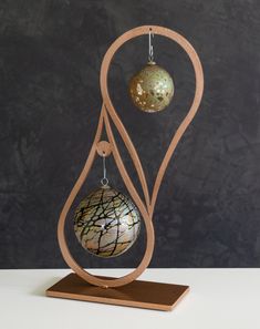 an ornament with two ornaments hanging from it's sides on a wooden stand