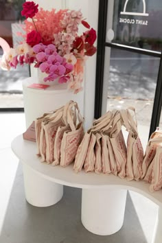 three pairs of shoes sitting on top of a table next to a vase with flowers