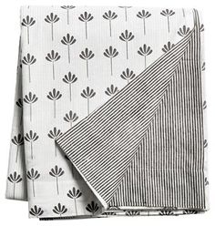 two napkins on top of each other with black and white flower designs in them