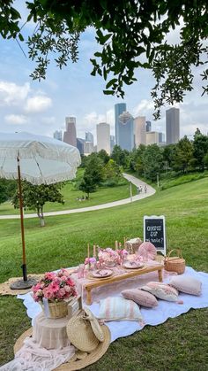 a picnic table set up with pink flowers and pillows