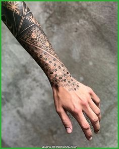 a man's arm with an intricate tattoo design on the left hand and wrist