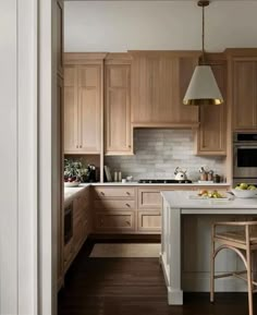 a kitchen with wooden cabinets and white counter tops, along with a bar stool that matches the hardwood flooring