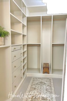 a walk in closet with white shelving and rug on the floor next to it