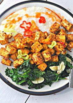 a white plate topped with tofu and greens