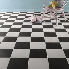 a chair sitting on top of a black and white checkered floor next to a wall