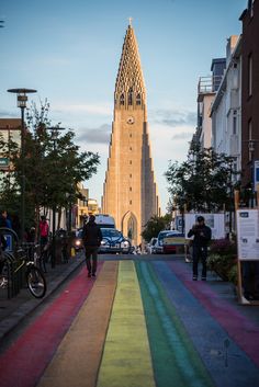 a rainbow painted street in front of a tall building