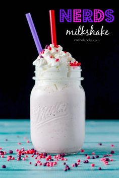 a mason jar filled with whipped cream and sprinkles on a blue table