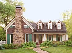 a brick house with white trim and green shutters