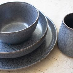 a set of four gray dishes sitting on top of a table