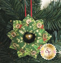 a green ornament hanging from a christmas tree