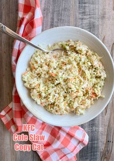 a white bowl filled with coleslaw on top of a red and white checkered napkin