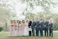 a group of people standing next to each other on top of a grass covered field