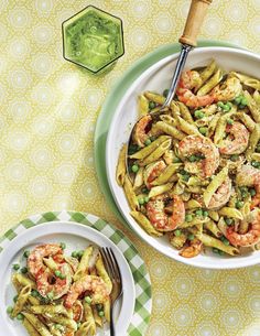 two plates of pasta with shrimp and peas