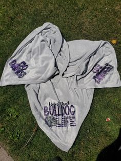 two towels laying on top of the grass with writing on them that says, i love my bulldog life