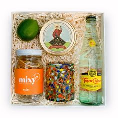 an assortment of drinks and condiments in a gift box with rice, lime