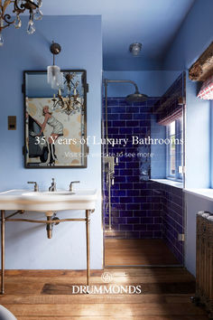 a bathroom with blue walls and wood flooring next to a white sink under a window