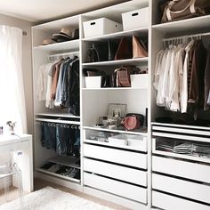 a white closet filled with lots of clothes and bags on top of shelves next to a window