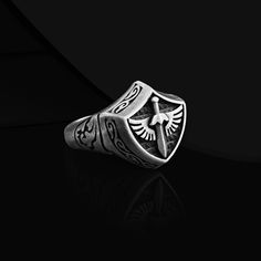 Silver Knight Ring for Men Introducing our extraordinary Sterling Silver Knight Ring for Men, a magnificent statement piece for the modern gentleman. Crafted with meticulous attention to detail, this mens shield oxidized signet ring showcases a bold design reminiscent of a mighty sword and shield. The unique combination of sterling silver and exquisite oxidized accents exudes a sense of strength and courage. Whether it's a special occasion or just a regular day, this remarkable ring is the best gift choice for that special man in your life. It symbolizes bravery and resilience, making it an ideal accessory to elevate any outfit. Wear this shield ring with pride and command attention wherever you go. Product Code: FRMSO102 Product Name: Silver Knight Ring for Men Metal: Handmade red enamele Knight Ring, Silver Knight, Ring For Man, Shield Ring, 22 Carat Gold, Modern Gentleman, Jewelry Model, Ring For Men, Unique Ring