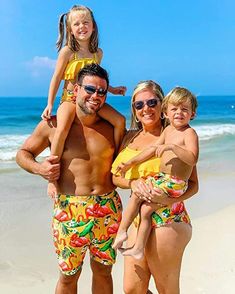 a man, woman and child are standing on the beach with their arms around each other