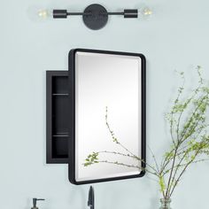 a bathroom sink with a mirror above it and a vase on the counter next to it