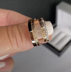 a woman's hand holding three different rings