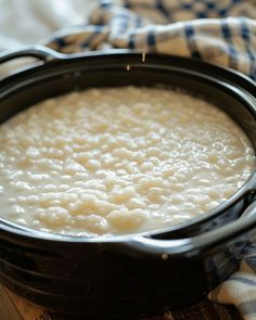 a pot filled with rice sitting on top of a wooden table