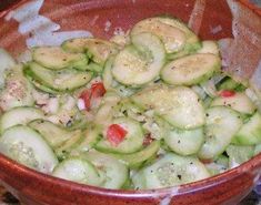 a bowl filled with cucumbers sitting on top of a table