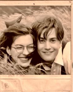 two young people are posing for a photo in front of some tall grass and one is smiling at the camera