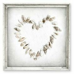 a heart made out of seashells in a frame