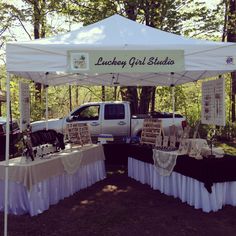 a truck parked under a white tent with black and white tablecloths on it