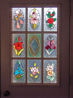 a close up of a glass door with flowers in the window panes on it