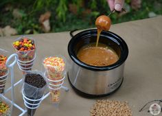 a person pouring candy into a crock pot with other candies in the background