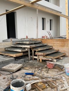 an unfinished building with steps and buckets on the ground