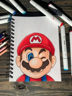 a drawing of mario on paper next to crayons