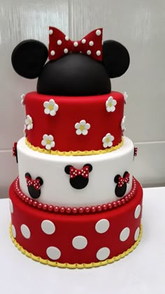 a three tiered cake decorated with minnie mouse ears