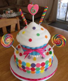 a multi layer cake decorated with candy and lollipops