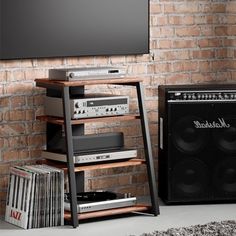 an entertainment center in front of a brick wall with a television and speakers on it