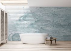 a white bath tub sitting on top of a wooden floor next to a wall mounted heater