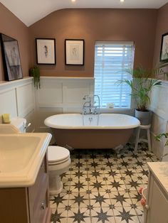 a bath room with a toilet a sink and a bath tub next to a window