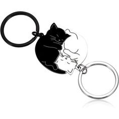 a black and white cat keychain with an image of a sleeping cat on it's back