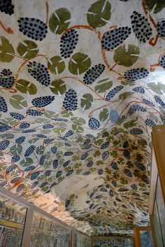 the ceiling is decorated with leaves and other decorative things on display in an art gallery