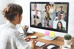 a woman sitting in front of a computer with many people on the screen