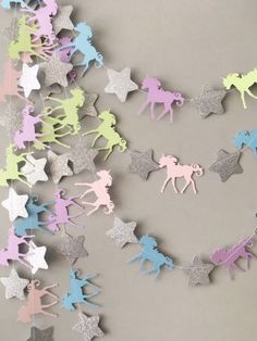 a string of paper cutouts with unicorns and stars