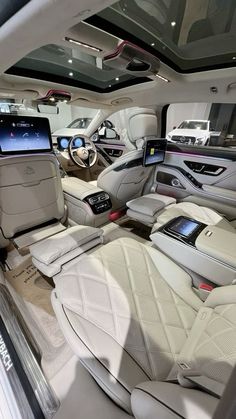 the interior of a luxury car with all white leather seats and dashboards on display