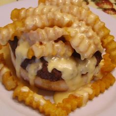 a hamburger covered in cheese on top of waffles