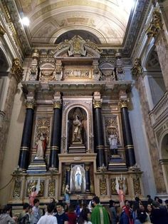 the inside of a church with many people standing around