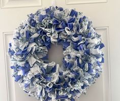 a blue and white wreath hanging on the front door